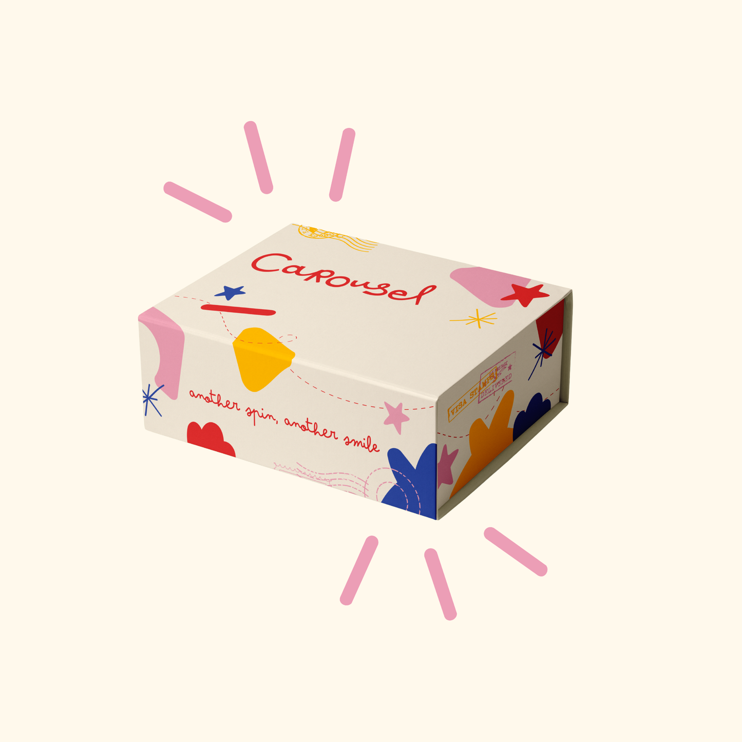 A rectangular product box with a cream background and colorful abstract illustrations, including the word 'Carousel' in red script. The box is shown on a light cream background with decorative pink radiating lines around it.