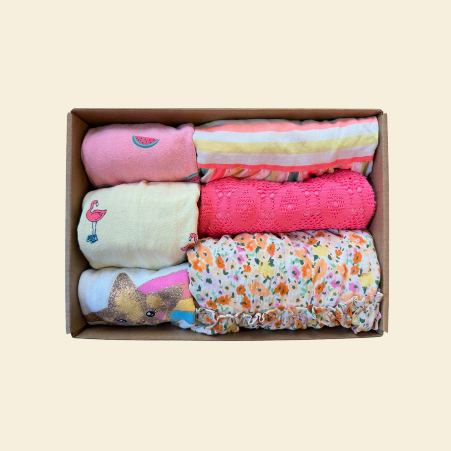box of girl's clothing with pink, yellow and floral styles