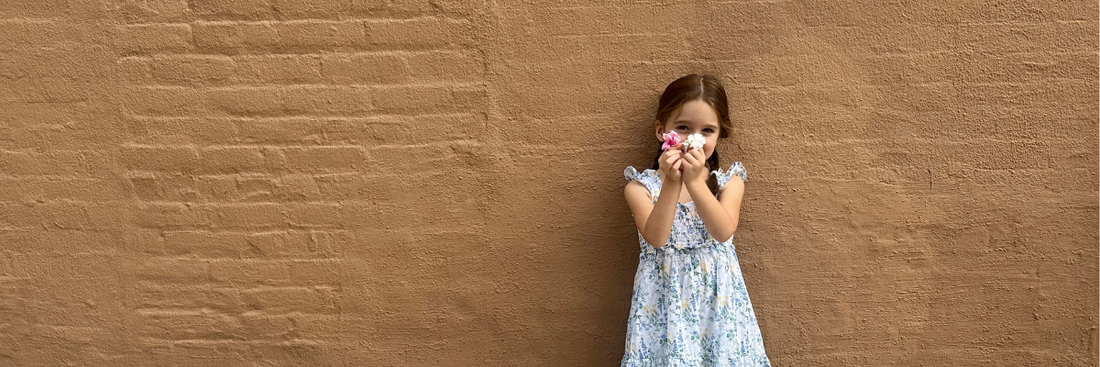 Young girl wearing dress holding flowers