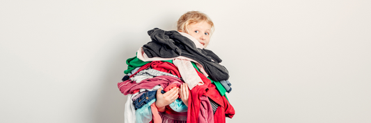 young girl holding a pile of clothes
