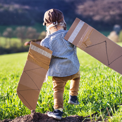 toddler boy outdoors with pilot outfit made with cardboard wings