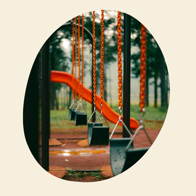 Children's playground with swings and a slide in a park setting